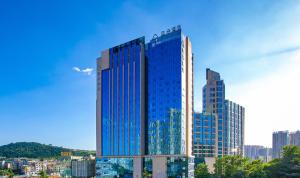 贵阳贵阳世纪城购物中心亚朵酒店的一座高大的建筑,有蓝色的窗户,位于城市