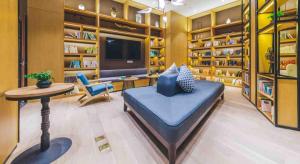 滨海新区天津滨海二大街亚朵酒店的一间配备有蓝色沙发和一张桌子的大客厅