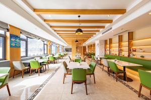 拉萨拉萨布达拉宫亚朵酒店的用餐室配有桌子和绿色椅子