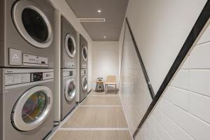 嘉定上海嘉定菊园智慧中心亚朵酒店的洗衣房配有一排洗衣机