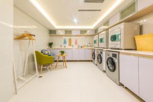 乌鲁木齐乌鲁木齐人民电影院亚朵酒店的一间大型的白色洗衣房,配有洗衣机和烘干机