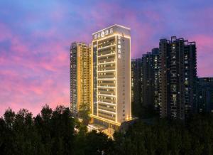 深圳Atour S Hotel Shenzhen Futian Port的黄昏时在城市里建起一座有照明的建筑