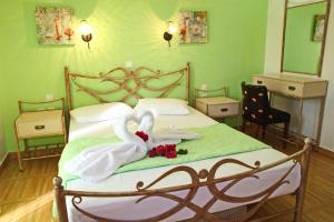 艾拉方索斯Coralli Rooms & Restaurant的一张带两条毛巾和两只天鹅的床