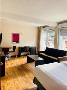 阿克斯莱泰尔姆Résidence Le Grand Tétras- SPA THERMAL INCLUS的酒店客房配有床、沙发和桌子。