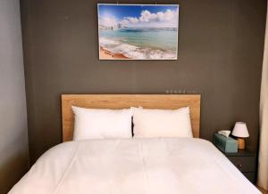 釜山Haeundae Bona Travel的一间卧室配有一张床,享有海滩美景