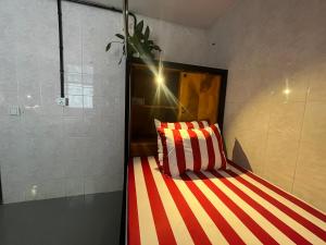 马德望Por Chey Hostel的一张红色和白色条纹的床
