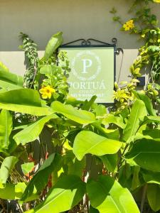 圣米格尔-杜斯米拉格里斯Portuá Chalés的绿叶和鲜花餐厅标志
