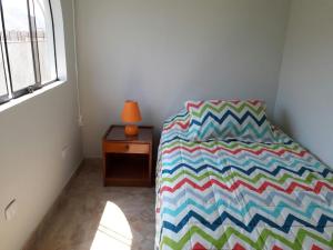 利马Terraza más habitaciones en La Molina的一间卧室配有一张带五颜六色棉被的床