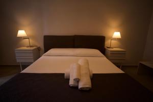 巴勒莫Donna Franca Rooms and Suite的一间卧室,床上配有两条毛巾和两盏灯
