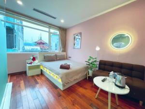河内MAY - TRENDY SKY VIEW - Phone 09756-59323的一间卧室配有一张床、一张沙发和一张桌子