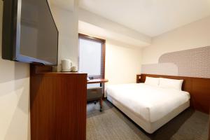 京都Hop Inn Kyoto Shijo Omiya的配有一张床和一台平面电视的酒店客房