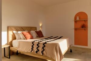 NgaringKawga Hôtel的一间卧室配有一张带橙色和白色枕头的大床