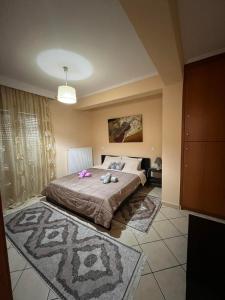 特里卡拉Bakopoulos resort.Ενα όμορφο διαμέρισμα με τζάκι的一间卧室,床上有粉红色的鲜花