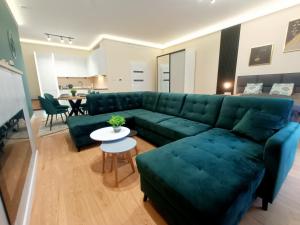 斯诺科Holi Resort的客厅配有绿色沙发和桌子