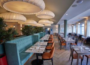 沃特福德沃特福德码头酒店的用餐室配有桌椅和吊灯。