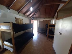 Rodeo de la CruzHostal de Los Andes的一间设有双层床的房间和一间带门的房间
