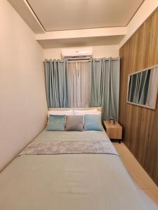 马尼拉Coast Residence Penthouse 40th Floor的小卧室配有带蓝色枕头的床