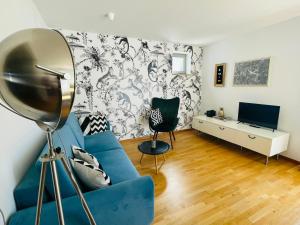 舍讷费尔德Fly Inn Apartment Berlin的客厅配有蓝色的沙发和电视
