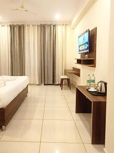 瑞诗凯诗Hotel Tapovanam Rishikesh的酒店客房,配有床和电视