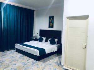 达瓦迪米افضل واحد للوحدات السكنية المخدومة - بست ون的一间卧室配有一张带蓝色窗帘的大床