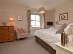 布里德波特3 Bed in Bothenhampton DC160的卧室配有床、椅子和窗户。