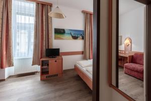 维也纳旗舰酒店的酒店客房,配有床、椅子和镜子