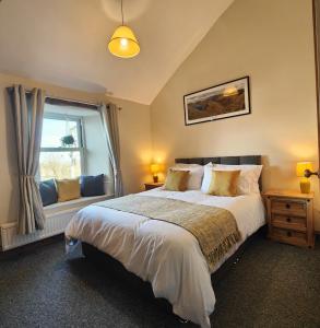 PenruddockThe Herdwick Inn的一间卧室设有一张大床和一个窗户。