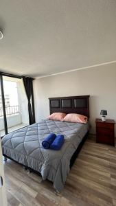 圣地亚哥Depto nuevo en republica cercano al movistar arena的一间卧室配有一张带两个蓝色枕头的床