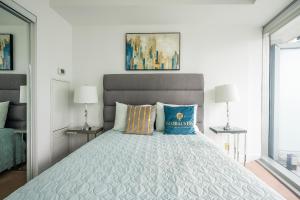 多伦多GLOBALSTAY. Amazing Downtown Apartments的一间卧室配有一张带蓝色枕头的大床