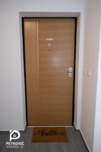 雅戈丁那Petković apartmani STUDIO32的一间房间中的木门,前面有垫子