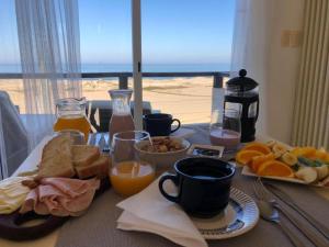 德尔迪阿布罗角Remanso del Diablo的一张带早餐食品的桌子,享有海滩美景