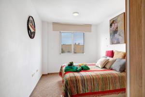塔扎克蒂Apartamento Rebeca的卧室配有一张床,墙上挂着一个钟