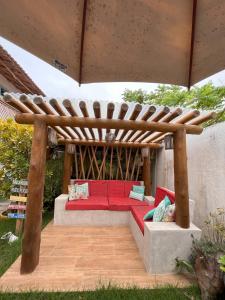 伊塔乌纳斯Pousada Vila Mar的木制凉棚下的红色沙发