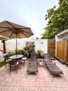 伊塔乌纳斯Pousada Vila Mar的庭院配有桌椅和遮阳伞。