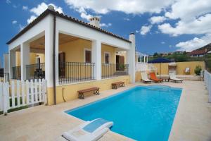 卡拉瓦杜斯Villa Karavisianikos Faros的一座带游泳池和房子的别墅