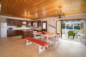 卡拉瓦杜斯Villa Karavisianikos Faros的厨房以及带桌椅的用餐室。