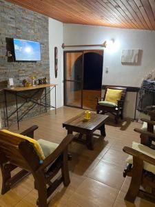 塔夸伦博Posada Mahatma的客厅配有木制家具和电视