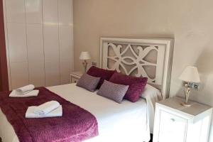 马林Piso con vistas a Loira的卧室配有一张带紫色枕头的大型白色床。