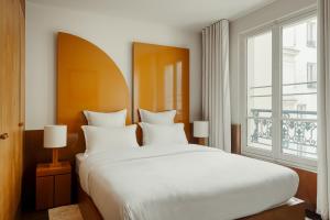 巴黎Edgar Suites - Bouchardon的卧室设有一张白色大床和一扇窗户。