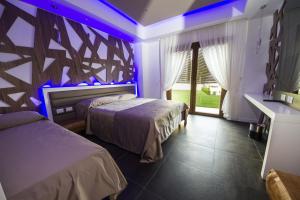 罗卡迪坎比奥鲁纳佩特住宿加早餐旅馆的紫色灯房内的两张床