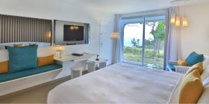 哥西尔拉克里奥尔海滩酒店及水疗中心的配有一张床、一张书桌和一扇窗户的酒店客房