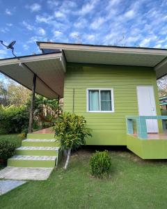 库德岛Suan Nai Kokut Resort的一座带门廊和楼梯的绿色小房子