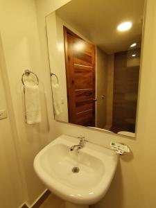 巴尼奥斯Airos Hotel的浴室设有白色水槽和镜子
