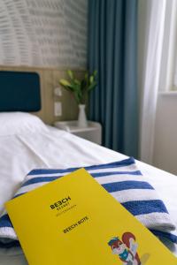 博尔滕哈根BEECH Resort Boltenhagen的床上的毛巾上有一个黄色的标志
