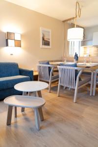 博尔滕哈根BEECH Resort Boltenhagen的客厅配有两张桌子和一张沙发