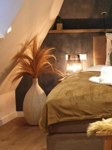 德科赫Suite De Brinkparel的一间卧室,配有一张床和一个花瓶