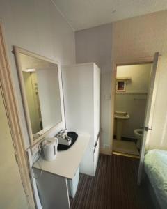 布莱克浦PRESTIGE PLAZA Hotel的客房设有书桌、床和浴室。