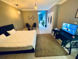 开罗Rove Residence New Cairo的一间卧室配有一张床、一张书桌和一台电视