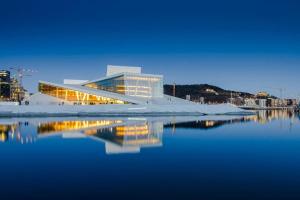 奥斯陆Luxurable super central 3 BR apt for a family of 6 in Oslo的水体中反射的建筑物