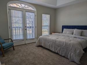 亚特兰大Spacious Luxury 3 Bedroom Townhouse in Summerhill, Downtown Atlanta的一间卧室配有一张床、一把椅子和窗户。
